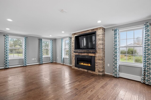 unfurnished living room featuring a wealth of natural light, a fireplace, dark hardwood / wood-style flooring, and ornamental molding