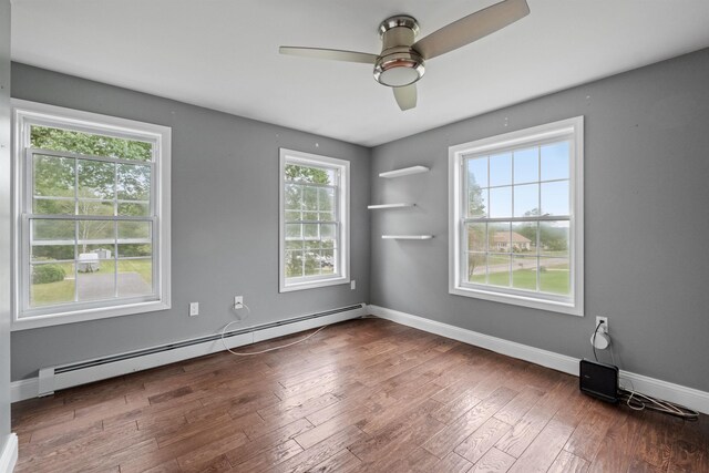 unfurnished living room with dark hardwood / wood-style floors, crown molding, plenty of natural light, and a stone fireplace