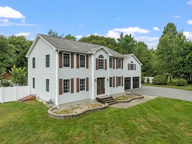 colonial inspired home featuring a front yard and a garage