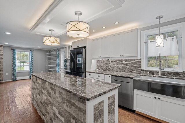 kitchen featuring dark hardwood / wood-style floors, decorative light fixtures, appliances with stainless steel finishes, a center island, and white cabinetry