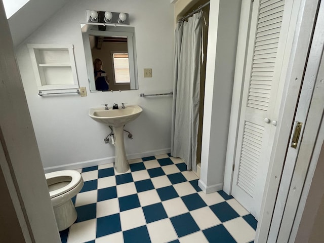 bathroom with toilet, a shower with curtain, built in shelves, and lofted ceiling