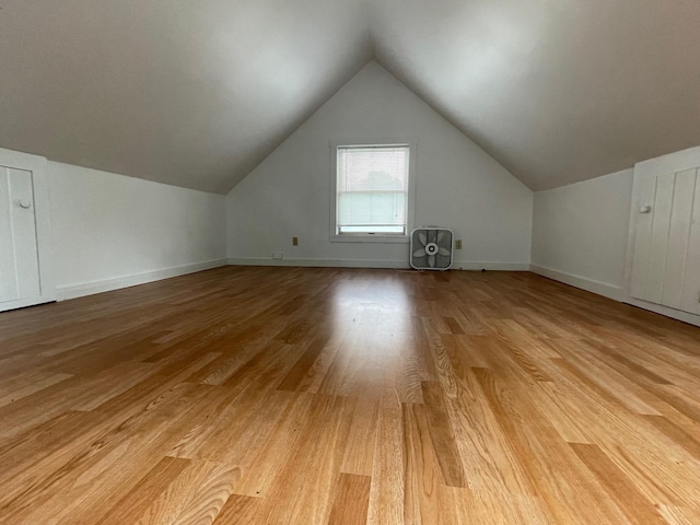 bonus room featuring light wood-type flooring, baseboards, and lofted ceiling