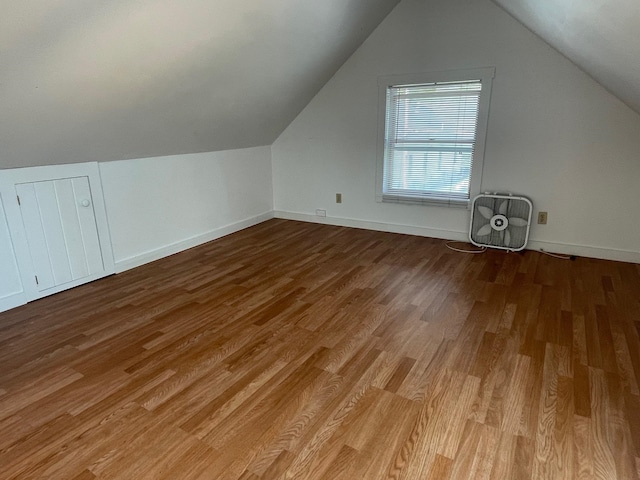 bonus room with light wood-type flooring and vaulted ceiling