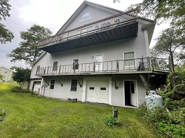 rear view of property with a balcony, a garage, and a yard