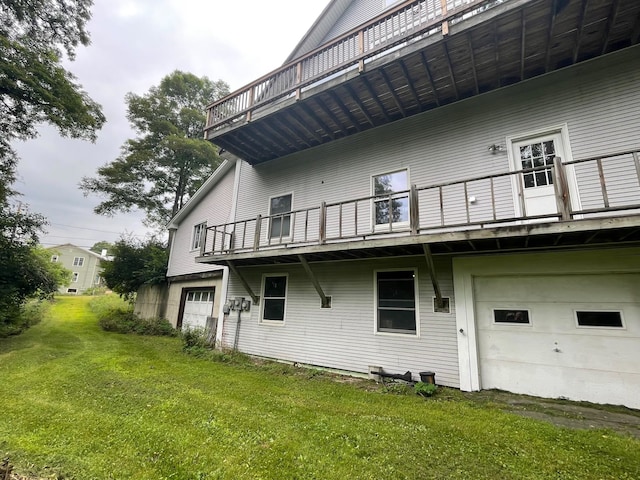 view of side of property featuring a garage, a balcony, and a lawn