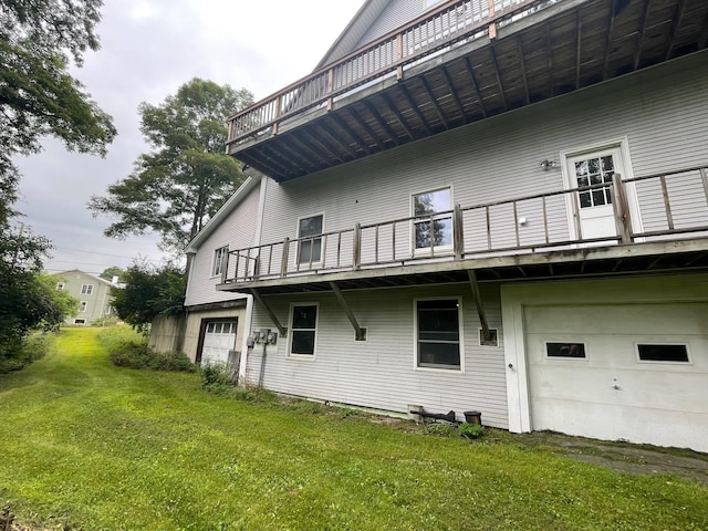 rear view of property featuring an attached garage and a lawn