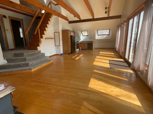 empty room with a wealth of natural light, a baseboard heating unit, and hardwood / wood-style floors