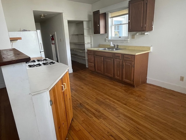 kitchen with sink, white appliances, and dark hardwood / wood-style flooring