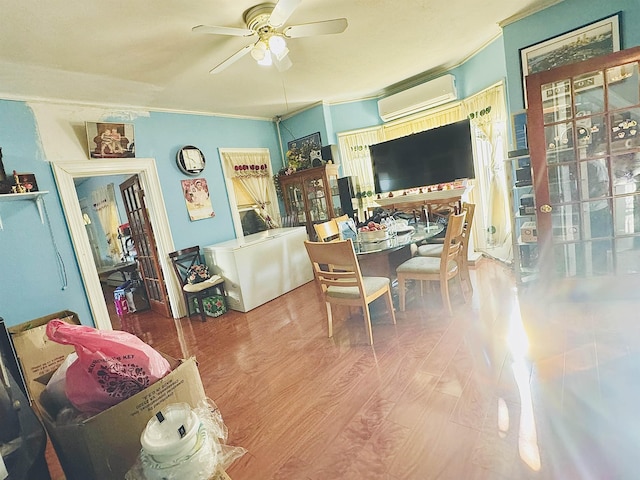 dining space featuring a ceiling fan, ornamental molding, wood finished floors, and a wall mounted AC