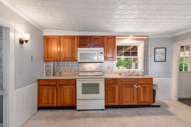 kitchen featuring crown molding, white appliances, light carpet, sink, and lofted ceiling