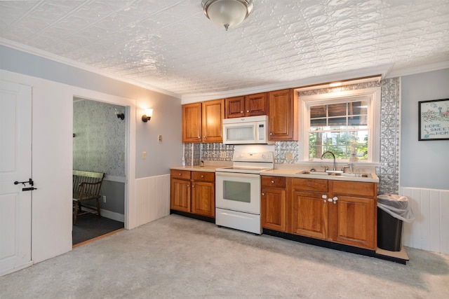 kitchen with crown molding, white appliances, sink, and light colored carpet