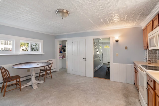 carpeted dining area featuring a baseboard heating unit, wooden walls, and crown molding