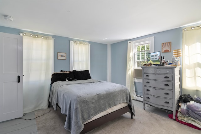 bedroom with a baseboard radiator and light carpet