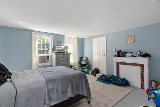 bedroom with cooling unit and a brick fireplace