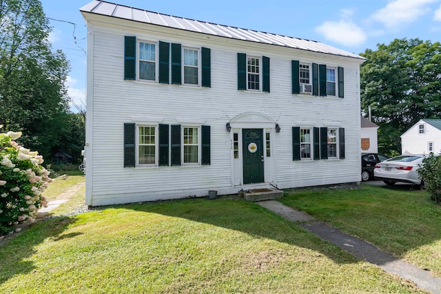 colonial inspired home featuring a front lawn