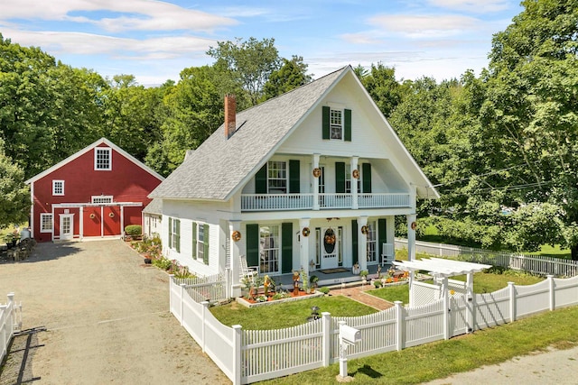 view of front of property with an outdoor structure, a front yard, and covered porch