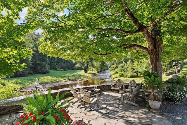 view of patio with a water view and a fire pit