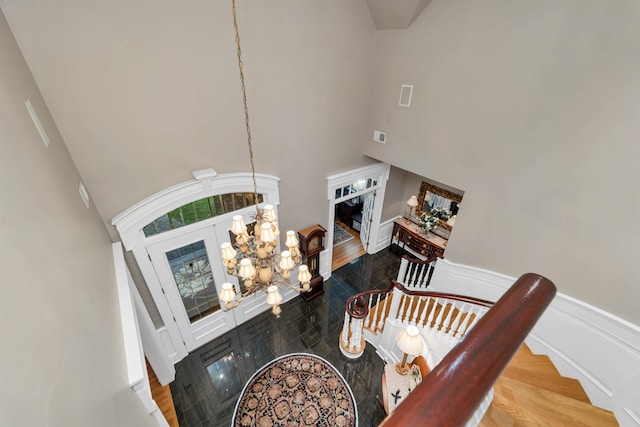 living room with a notable chandelier, hardwood / wood-style floors, and a high ceiling