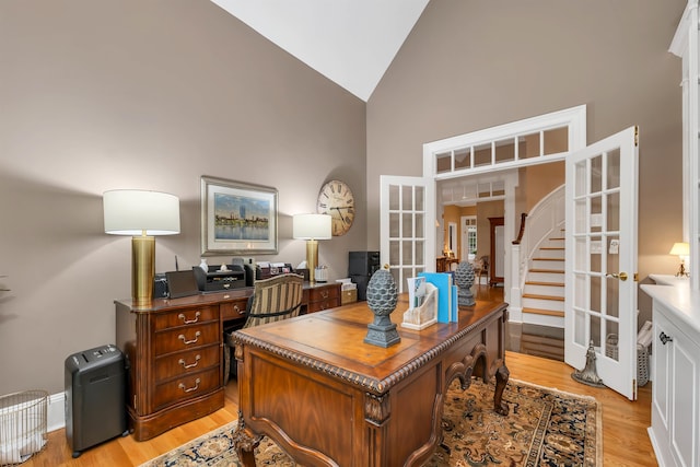 office featuring light wood-type flooring, french doors, and high vaulted ceiling