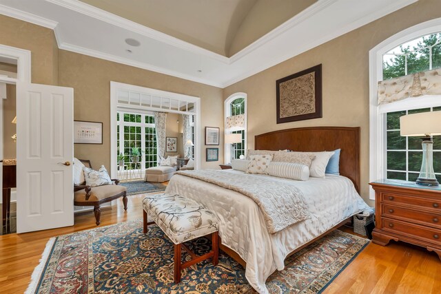 bedroom featuring ornamental molding, light hardwood / wood-style floors, access to exterior, and vaulted ceiling