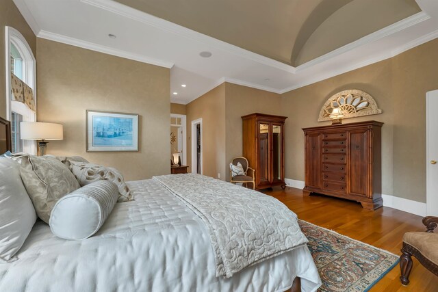 bedroom with vaulted ceiling, hardwood / wood-style flooring, and ornamental molding