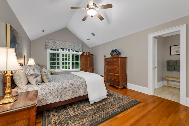 bedroom with ceiling fan, vaulted ceiling, and light hardwood / wood-style floors