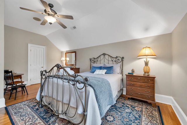 bedroom with vaulted ceiling, wood-type flooring, and ceiling fan