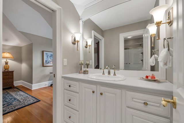 bathroom featuring a shower with shower door, hardwood / wood-style flooring, and vanity