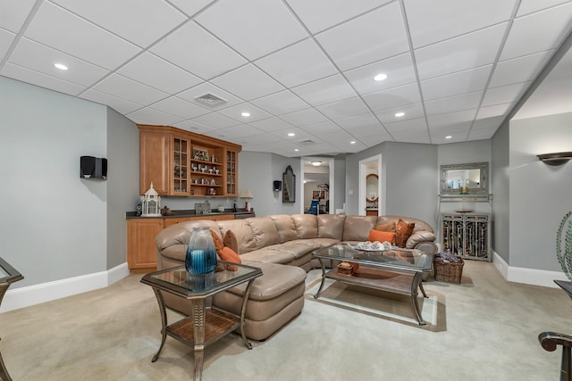 carpeted living room with indoor bar and a drop ceiling