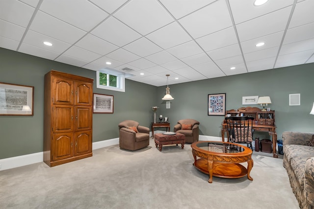 living room with a paneled ceiling and carpet