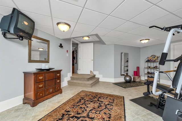 exercise area featuring tile patterned flooring and a drop ceiling