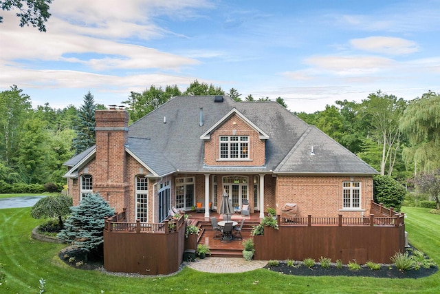 rear view of property with a yard and a deck