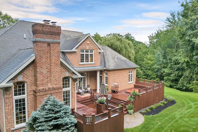 rear view of property with a yard and a wooden deck