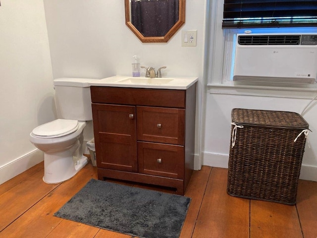 bathroom featuring wood-type flooring, toilet, and vanity