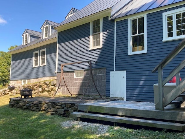 rear view of property with a fire pit and a wooden deck