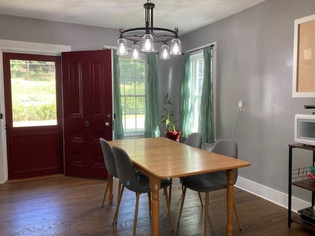 dining area with dark hardwood / wood-style flooring and a chandelier