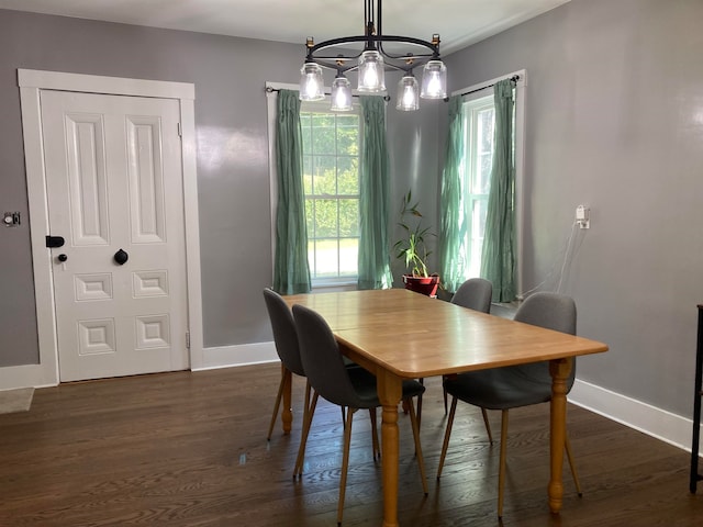 dining area featuring dark wood-type flooring and a chandelier