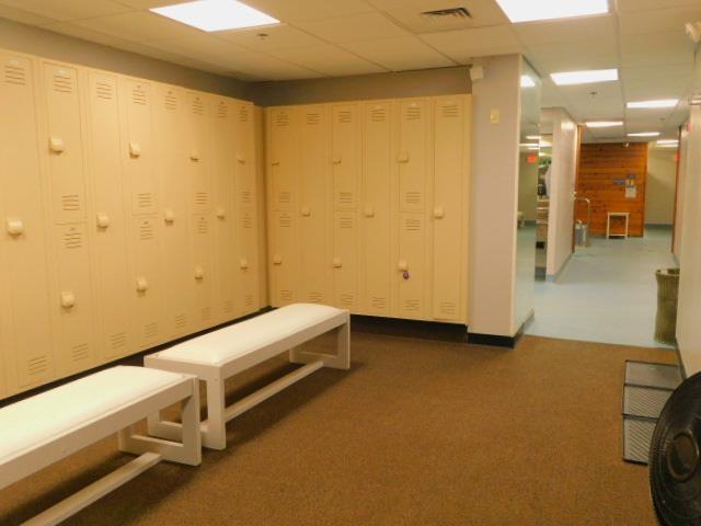 hallway featuring a drop ceiling, visible vents, and carpet floors