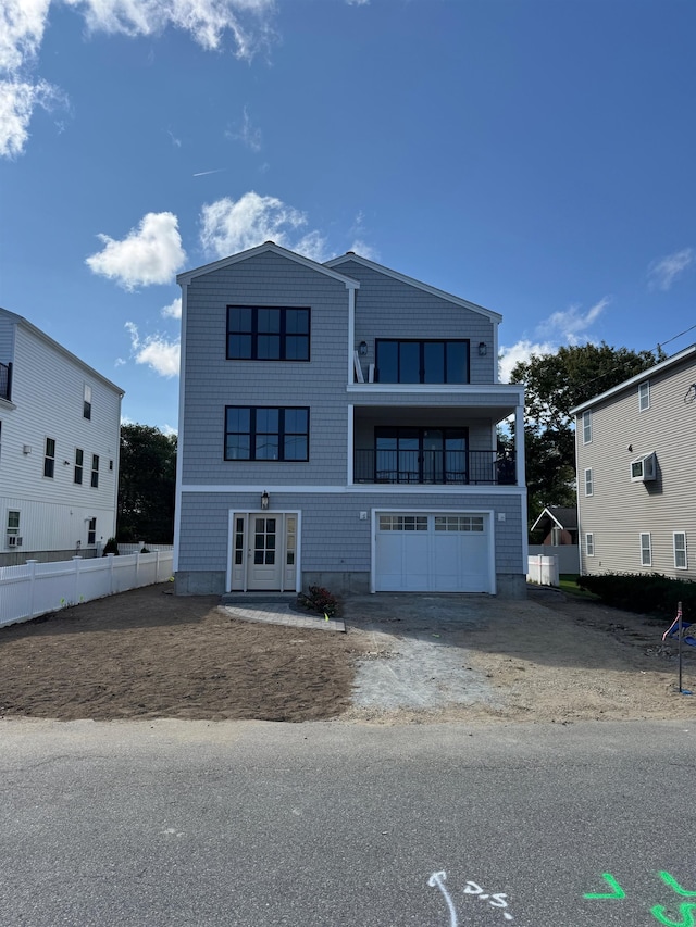 view of front of house with french doors, a garage, and a balcony