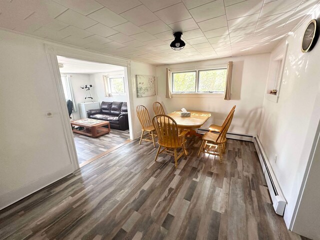 dining area featuring a baseboard heating unit and dark hardwood / wood-style floors