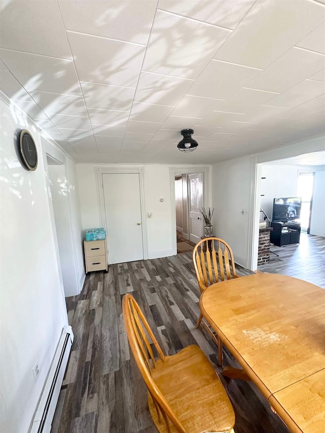 dining space featuring baseboard heating and dark hardwood / wood-style flooring