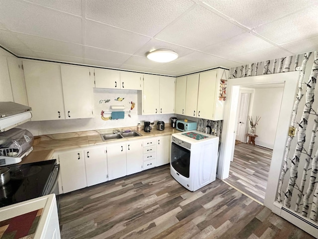 kitchen featuring white cabinetry, dark hardwood / wood-style flooring, baseboard heating, sink, and washer / dryer