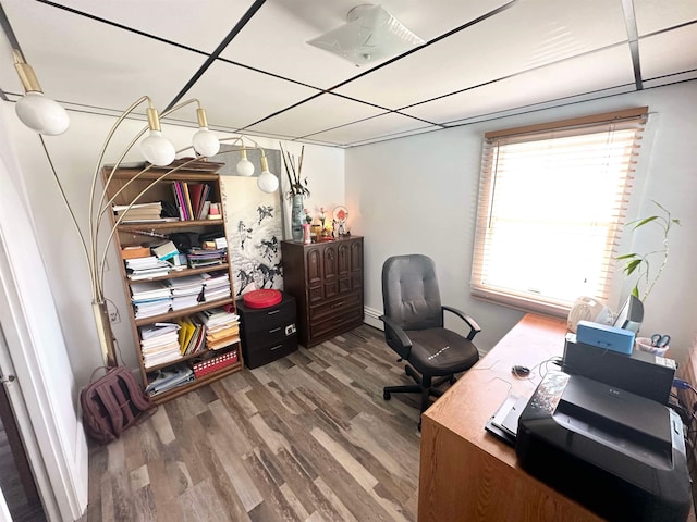 home office with a baseboard radiator, wood-type flooring, and a paneled ceiling