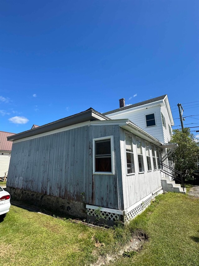 view of side of home with a lawn