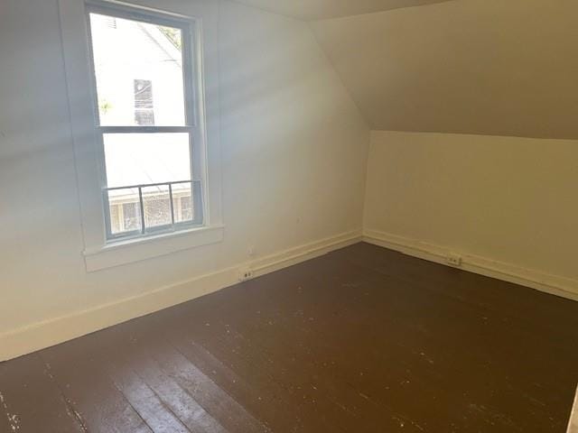 additional living space featuring hardwood / wood-style flooring and vaulted ceiling