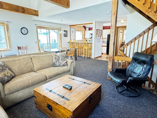 living room with carpet floors, vaulted ceiling with beams, and a textured ceiling