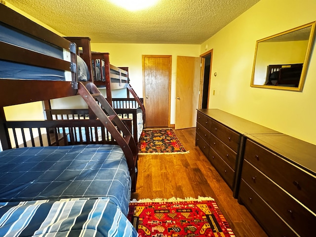 bedroom featuring dark hardwood / wood-style flooring and a textured ceiling