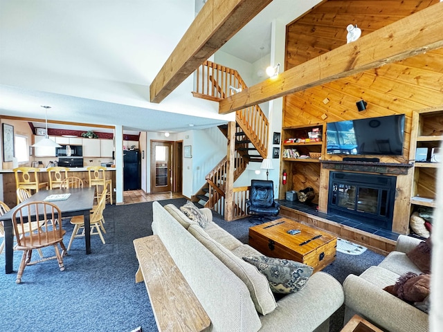 living room featuring beam ceiling, a fireplace, and carpet flooring