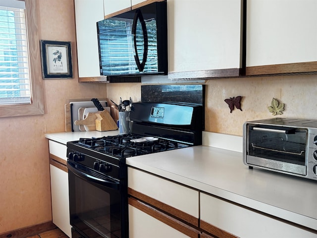 kitchen with white cabinets, backsplash, and black appliances