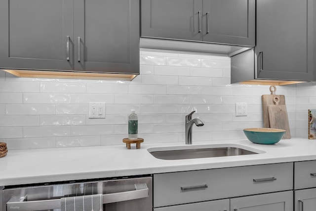 kitchen with gray cabinets, beverage cooler, tasteful backsplash, and sink